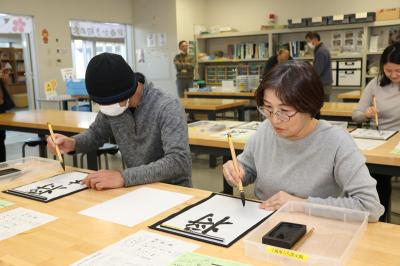 書初めを体験する参加者の写真