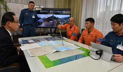 被災地での活動内容を地図を用いて濱田市長へ説明する消防隊員