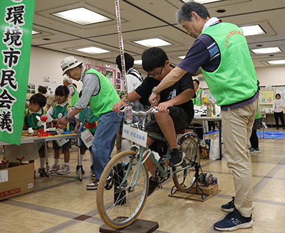 自転車発電体験をする子ども