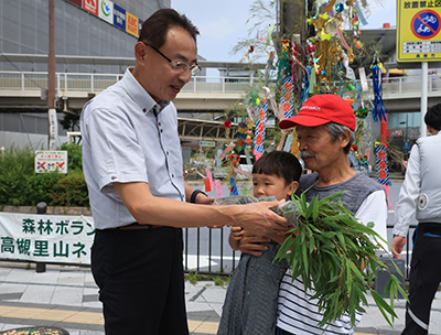 濱田市長からササを受け取る市民