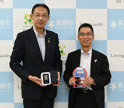 寄贈品を持つ大黒総括支配人と濱田市長