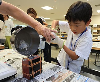 金属を型に流し入れる参加者