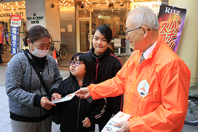 啓発物を市民に渡す石下副市長