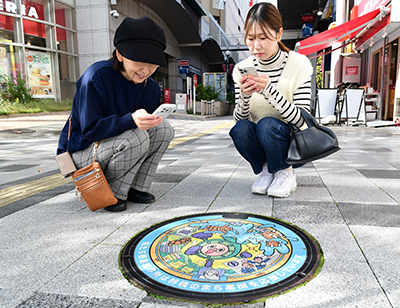 マンホールを撮影する人