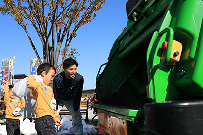 収集車にゴミを入れる来場者