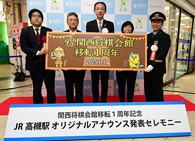 記念パネルを持つセレモニー参加者