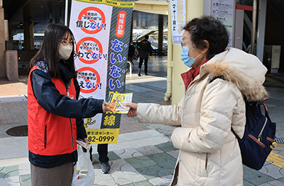 啓発物を市民に渡す職員