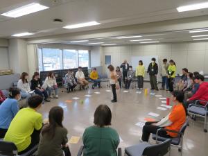 人が輪になって双六をしている様子