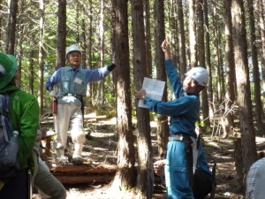 森で間伐の説明をしている写真