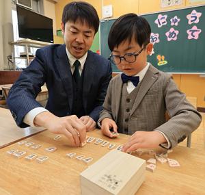配付された将棋駒を並べる親子