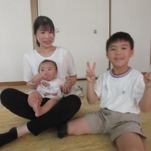 クイズに答えて嬉しそうにバッチをもらう男の子と家族