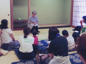 複数の来場者が畳に座り、おはなし会を聴いている様子。